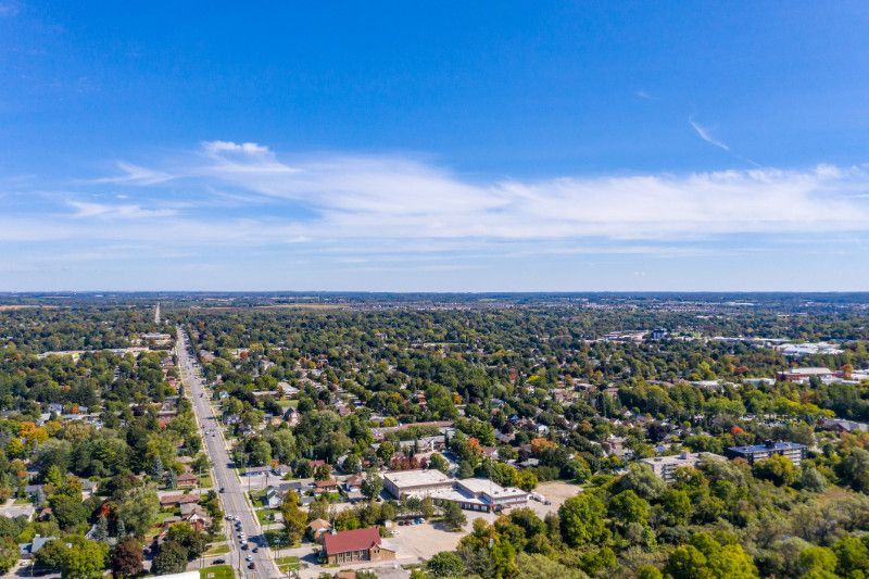 An aerial view of a residential area surrounded by trees on a sunny day.