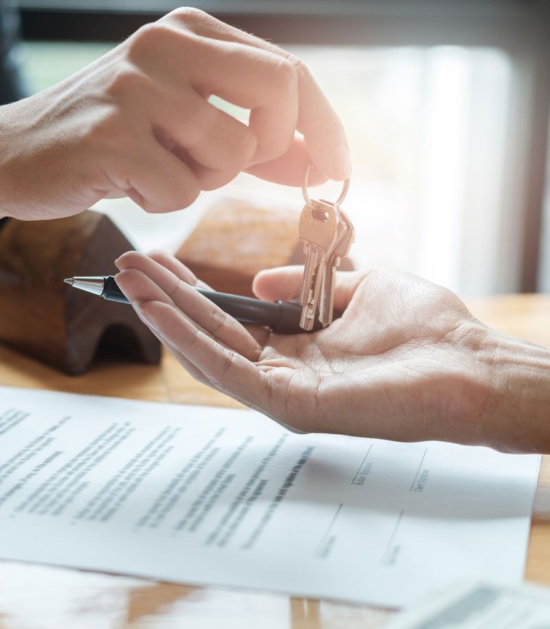 A person is handing a pen and keys to another person