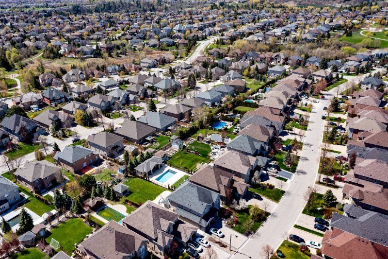 An aerial view of a residential area with lots of houses and a pool.