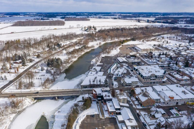 An aerial view of a small town surrounded by snow and a river.