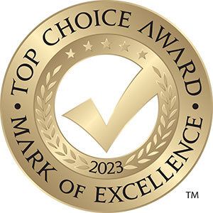 A gold top choice award mark of excellence stamp with a check mark in the center.