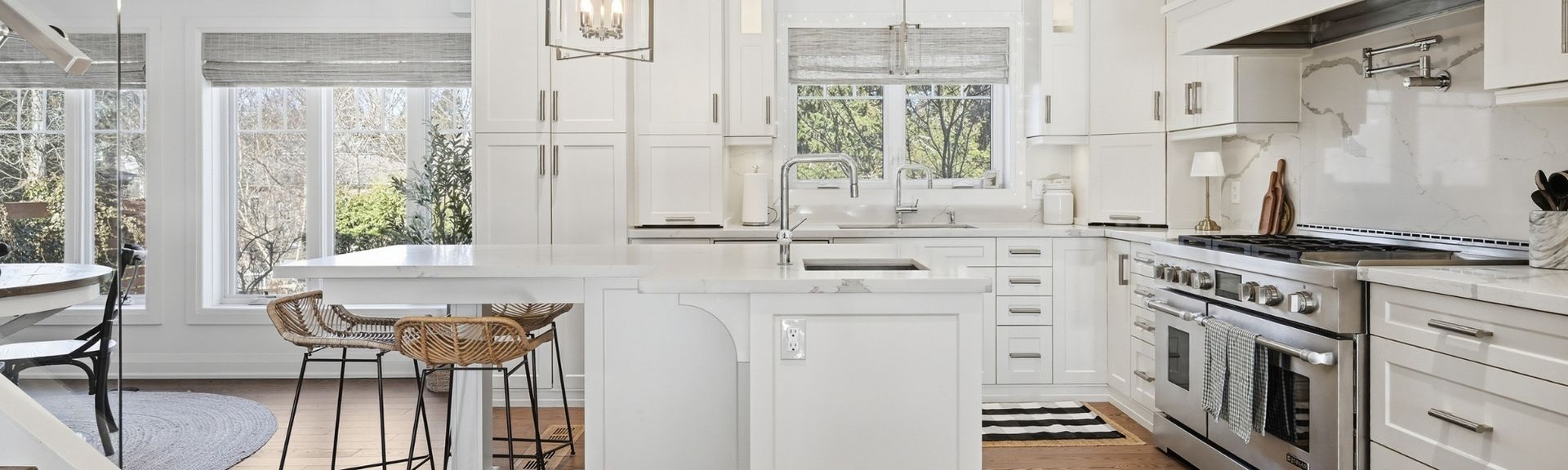 Photo of a modern kitchen with high-end stainless steel appliances and white cabinetry.