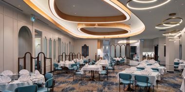 A large dining room with tables and chairs and a curved ceiling.