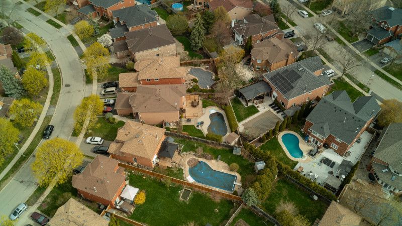 An aerial view of a residential neighborhood with lots of houses and a pool.