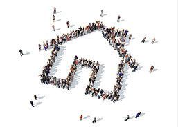 A large group of people are standing in the shape of a house.