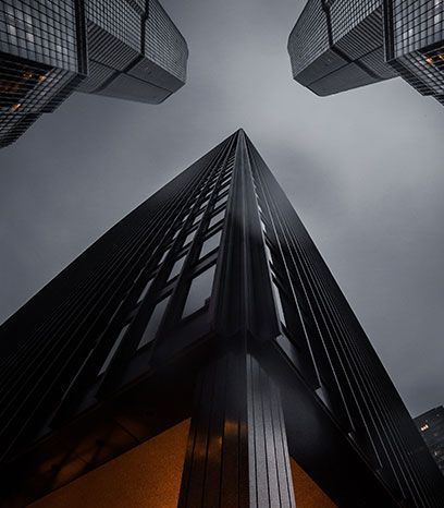Looking up at a tall building with a cloudy sky in the background