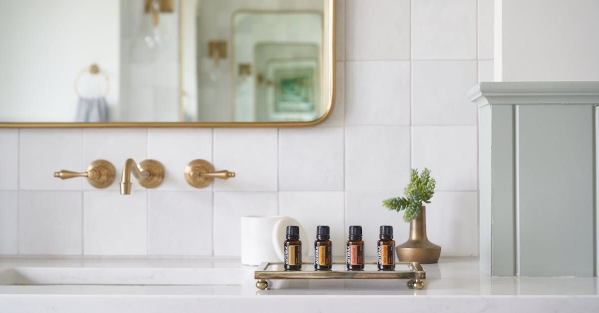 A bathroom sink with a mirror and a tray of bottles on it.