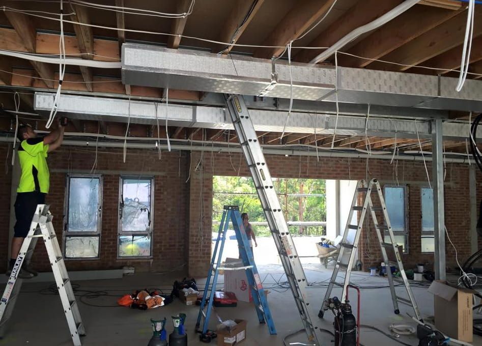 A Working Installing Air Conditioner Metal Pipes — Gordon's Air Conditioning & Refrigeration Services in Caloundra, QLD