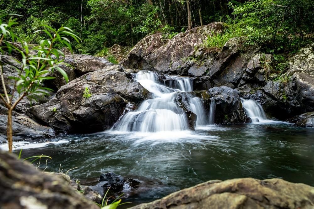 Small Waterfall Cascading Over Dark Rocks Into a Pool β Gordon's Air Conditioning & Refrigeration Services in Kenilworth, QLD