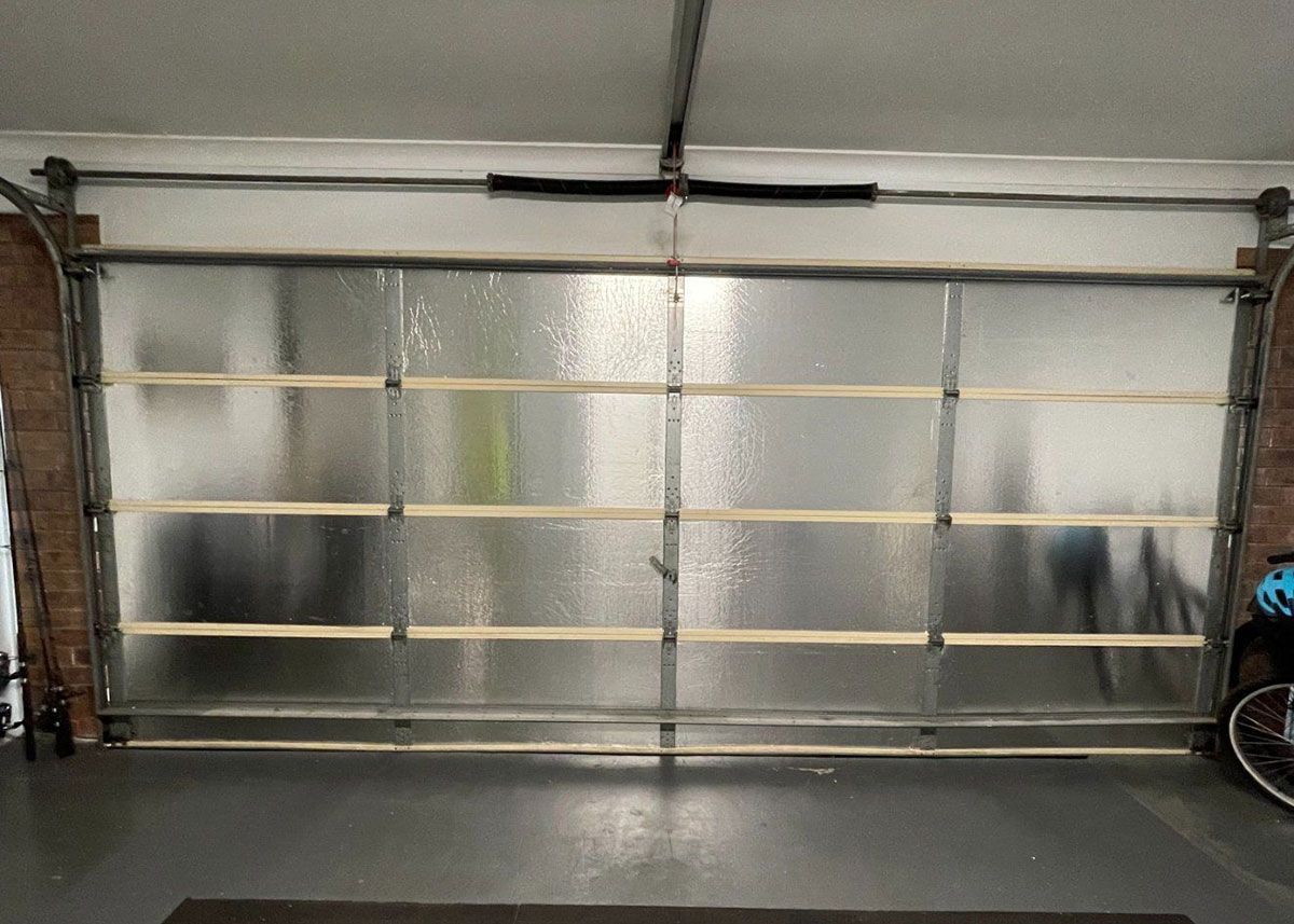 Garage door with frosted glass panels, wood support beams, and metal frame.