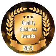 Quality Business Awards 2023 logo: gold shield with laurel wreath, text 