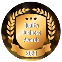 Quality Business Awards 2023 logo: gold shield with laurel wreath, text 