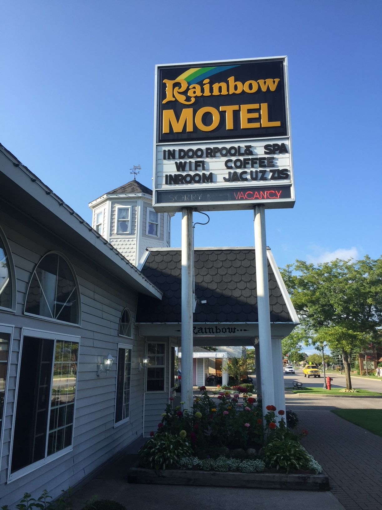 A sign for the rainbow motel is in front of a building