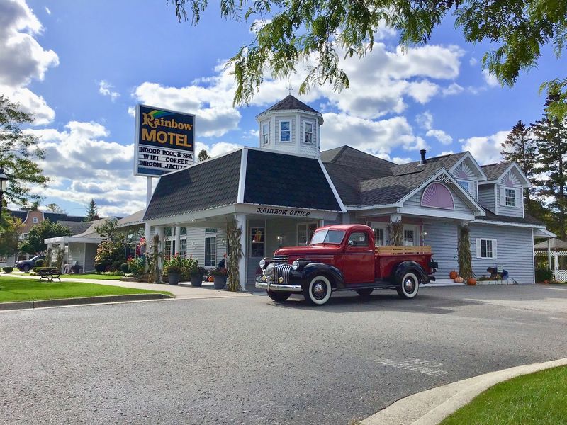 A red truck is parked in front of a motel.