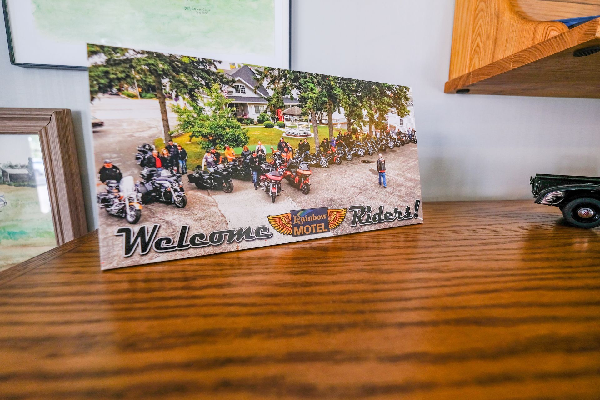A picture of a group of people riding motorcycles is sitting on a wooden table.