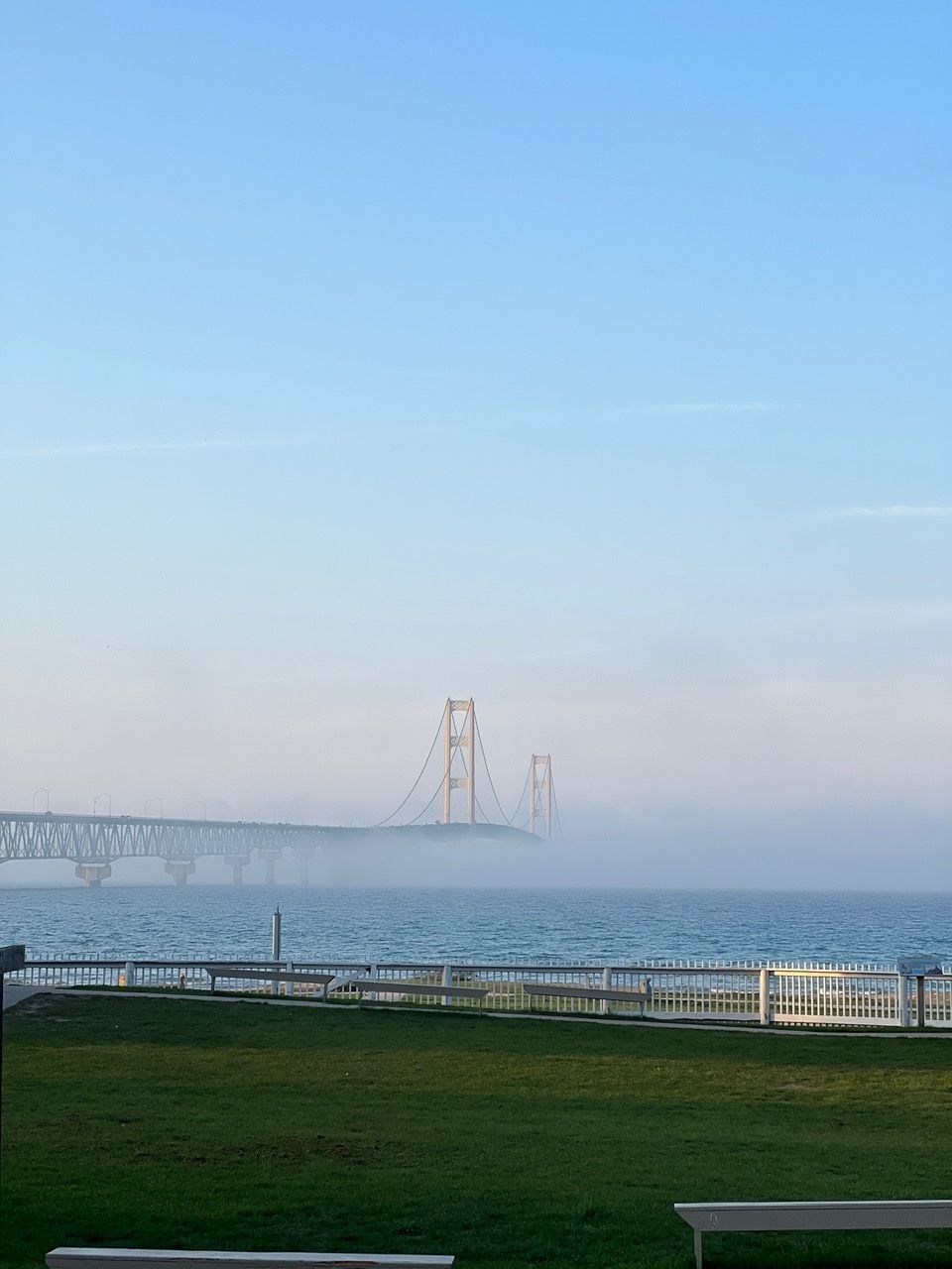 A bridge over a body of water with a bench in the foreground