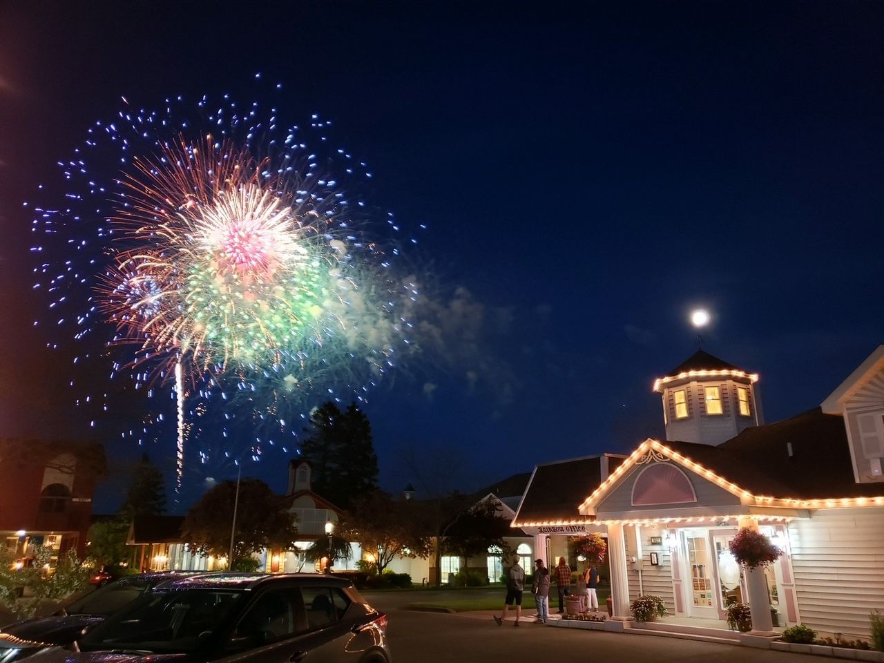 Fireworks are displayed over a building at night