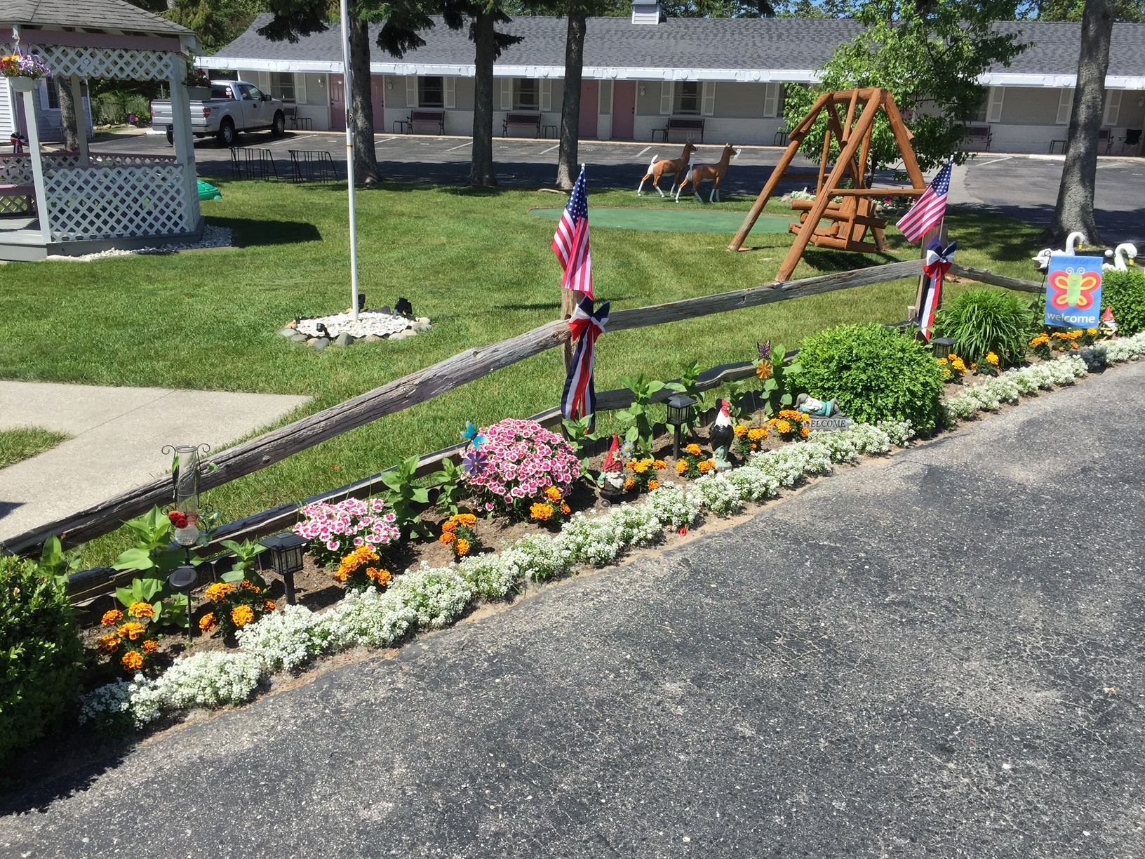 A garden with flowers and flags in front of a house