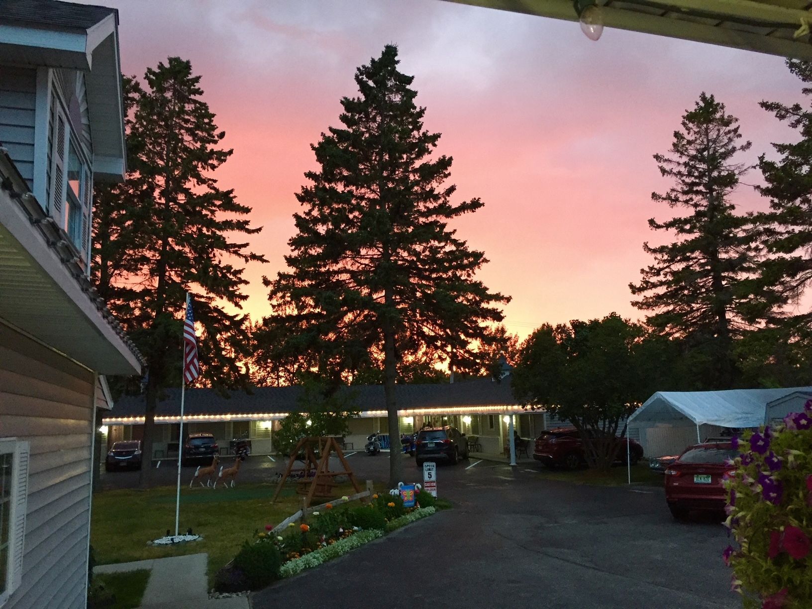 A sunset over a motel with trees in the foreground