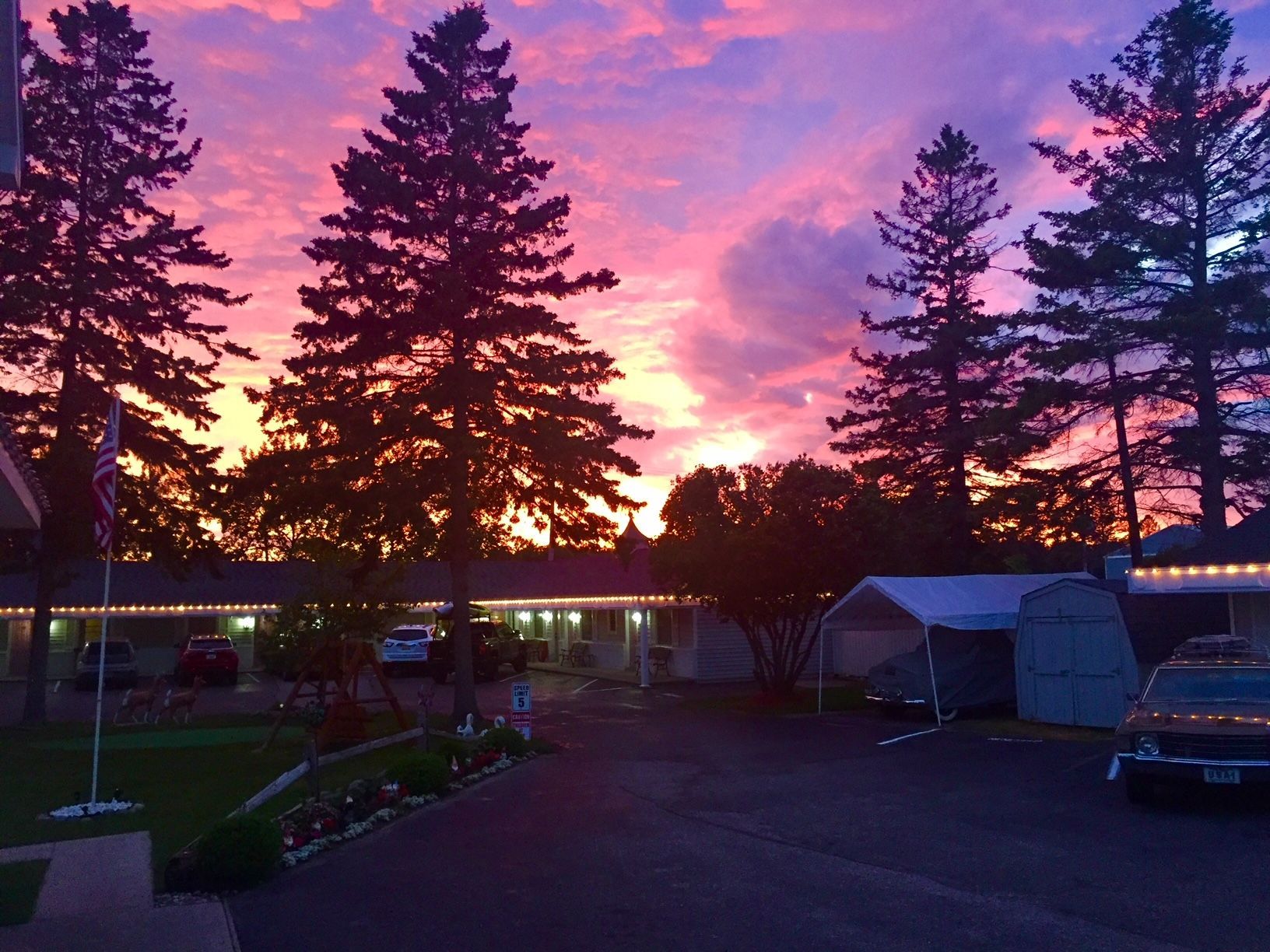 A sunset over a motel with trees in the foreground