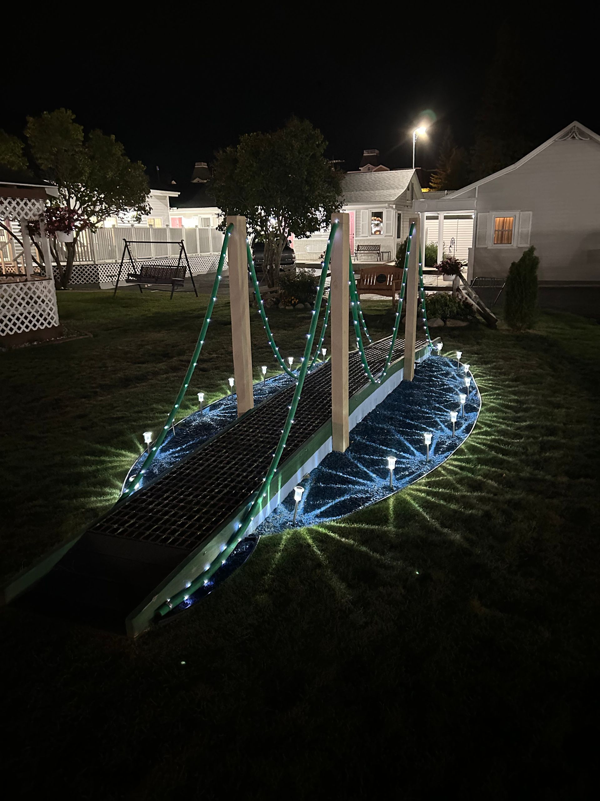 A bridge with christmas lights on it is lit up at night.