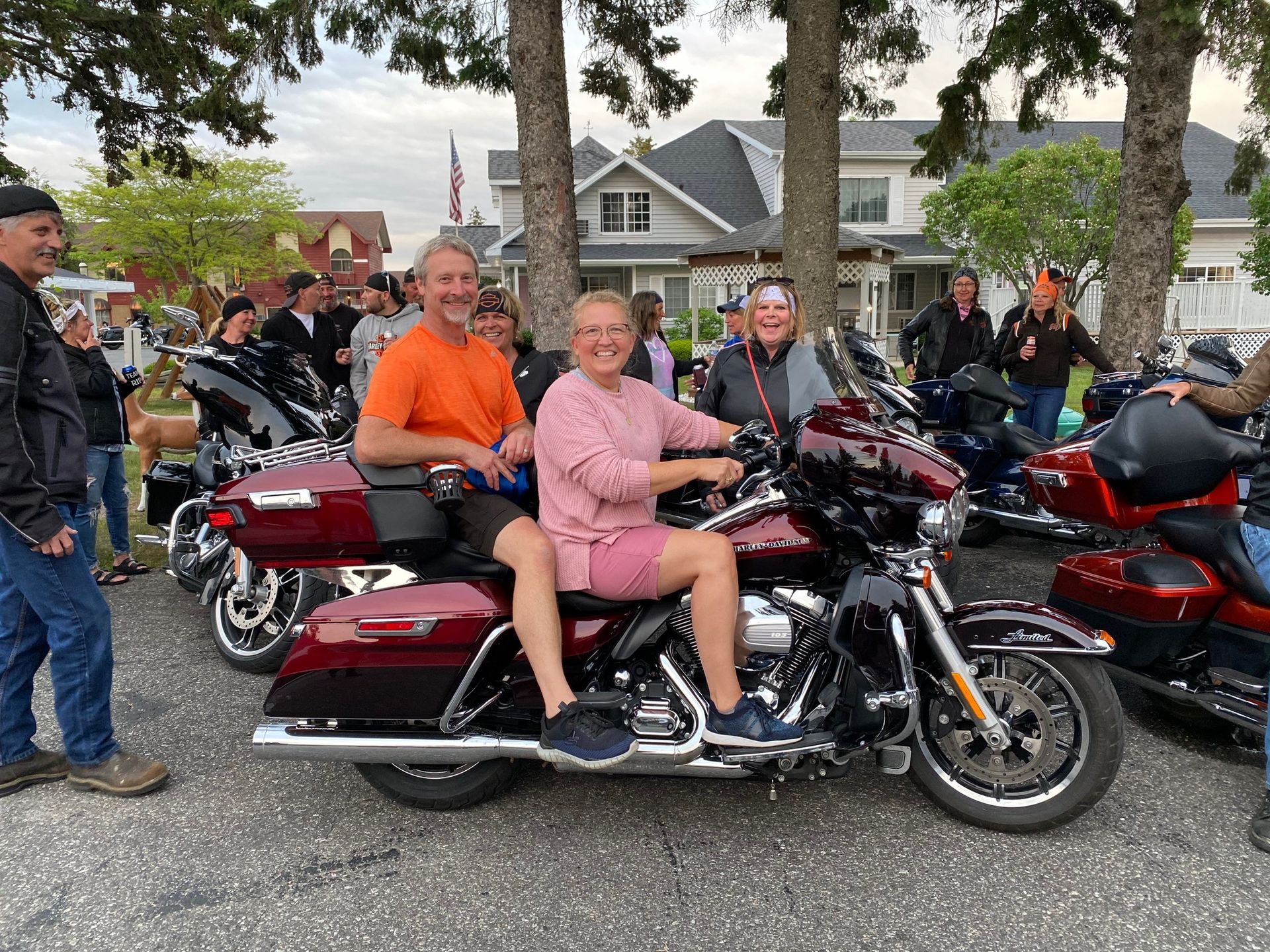 A group of people are standing around a row of motorcycles.