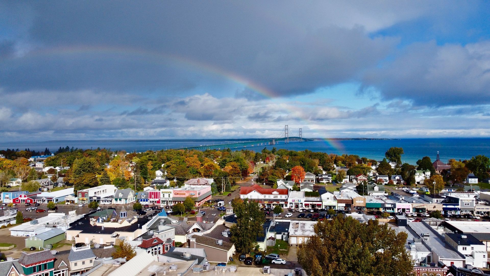 An aerial view of a small town with a rainbow in the sky.