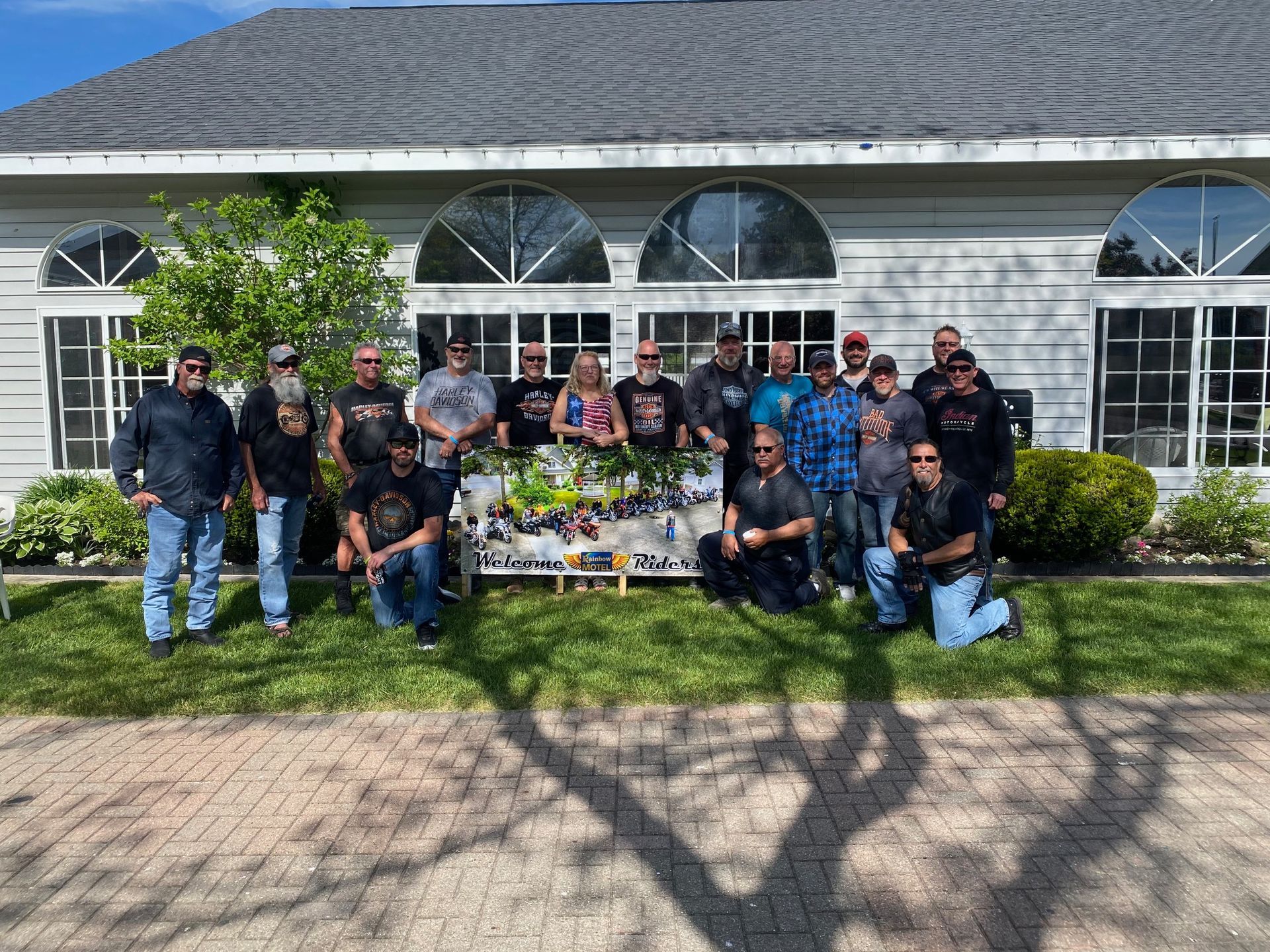 A group of men are posing for a picture in front of a house.