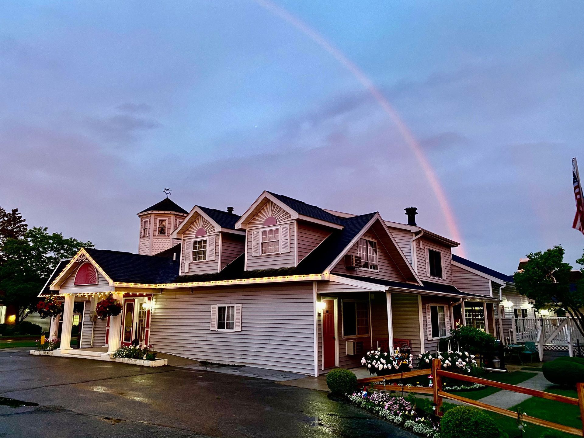 A house with a rainbow in the sky above it