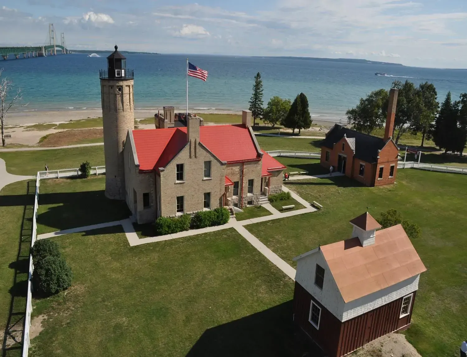An aerial view of a lighthouse with a red roof