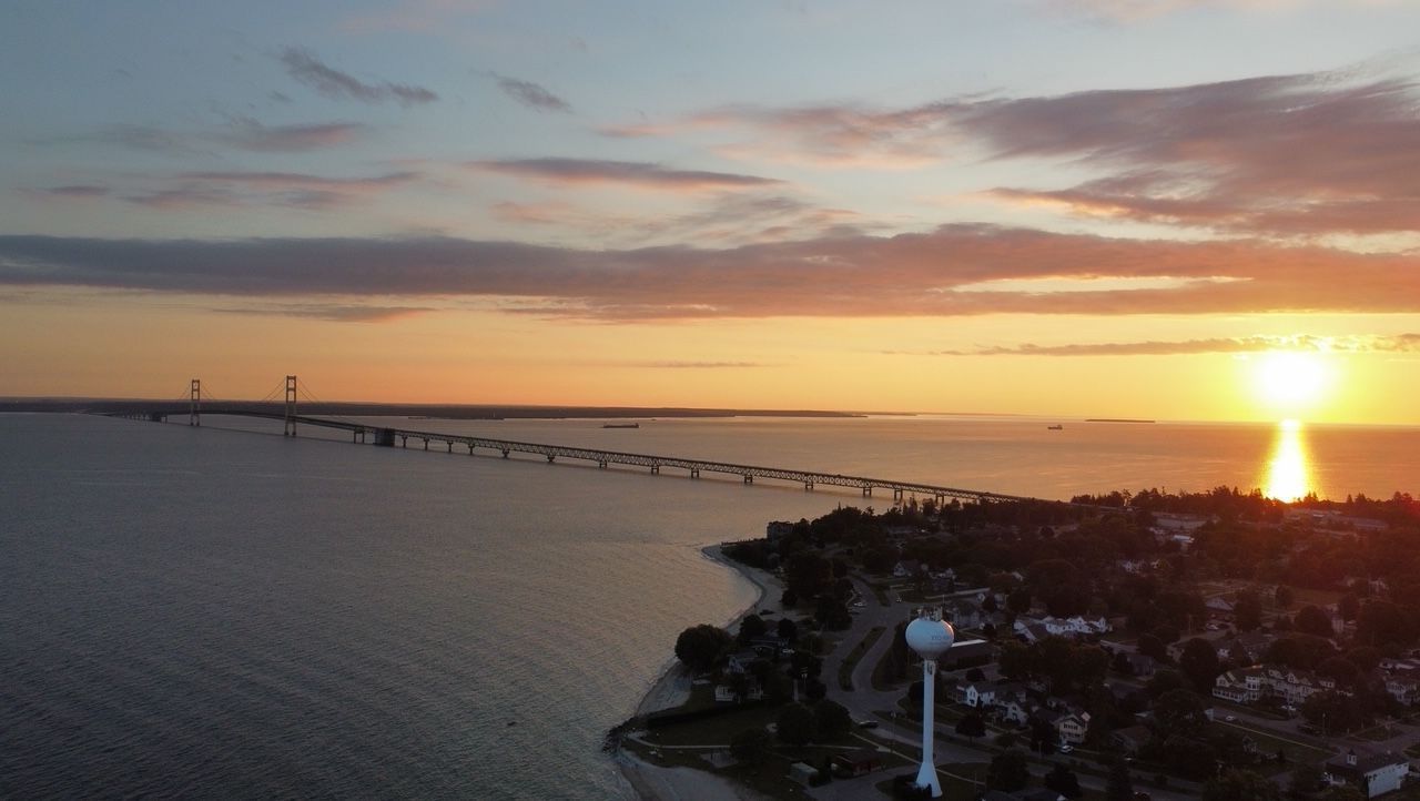 An aerial view of a bridge over a body of water at sunset.