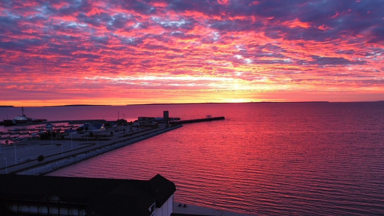 A sunset over a body of water with a dock in the foreground.