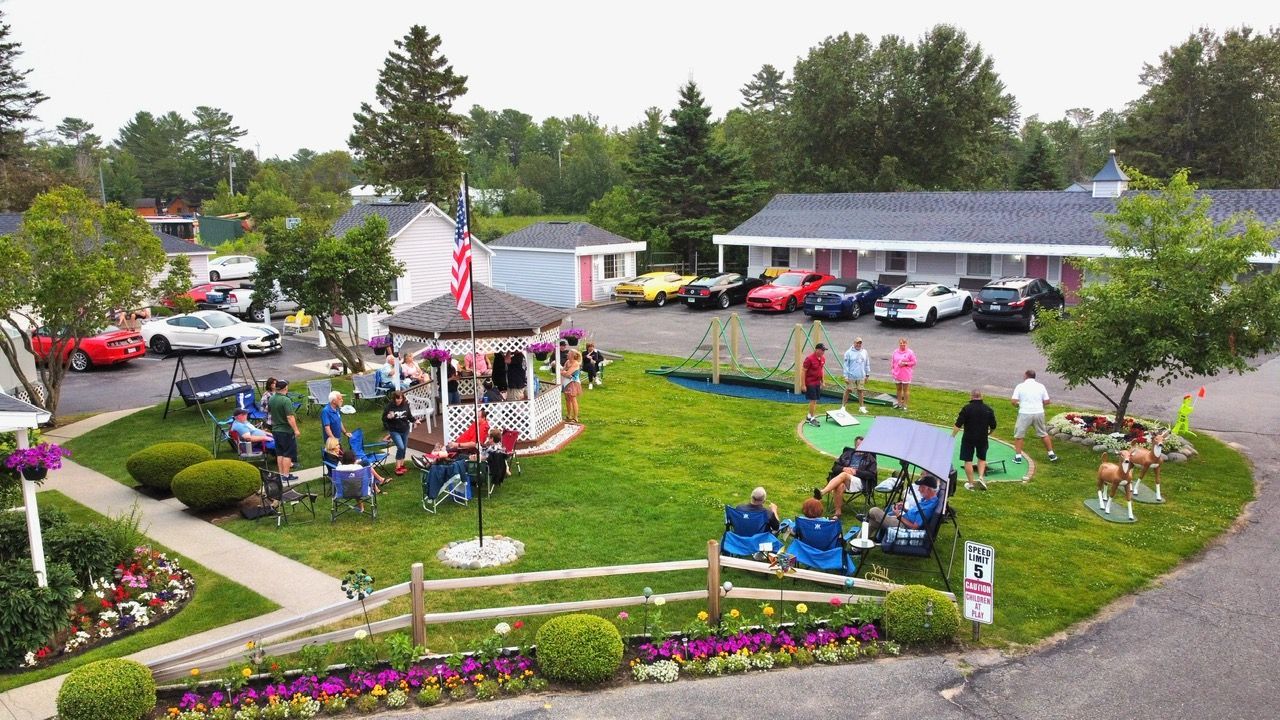 A group of people are sitting in a gazebo in a park.