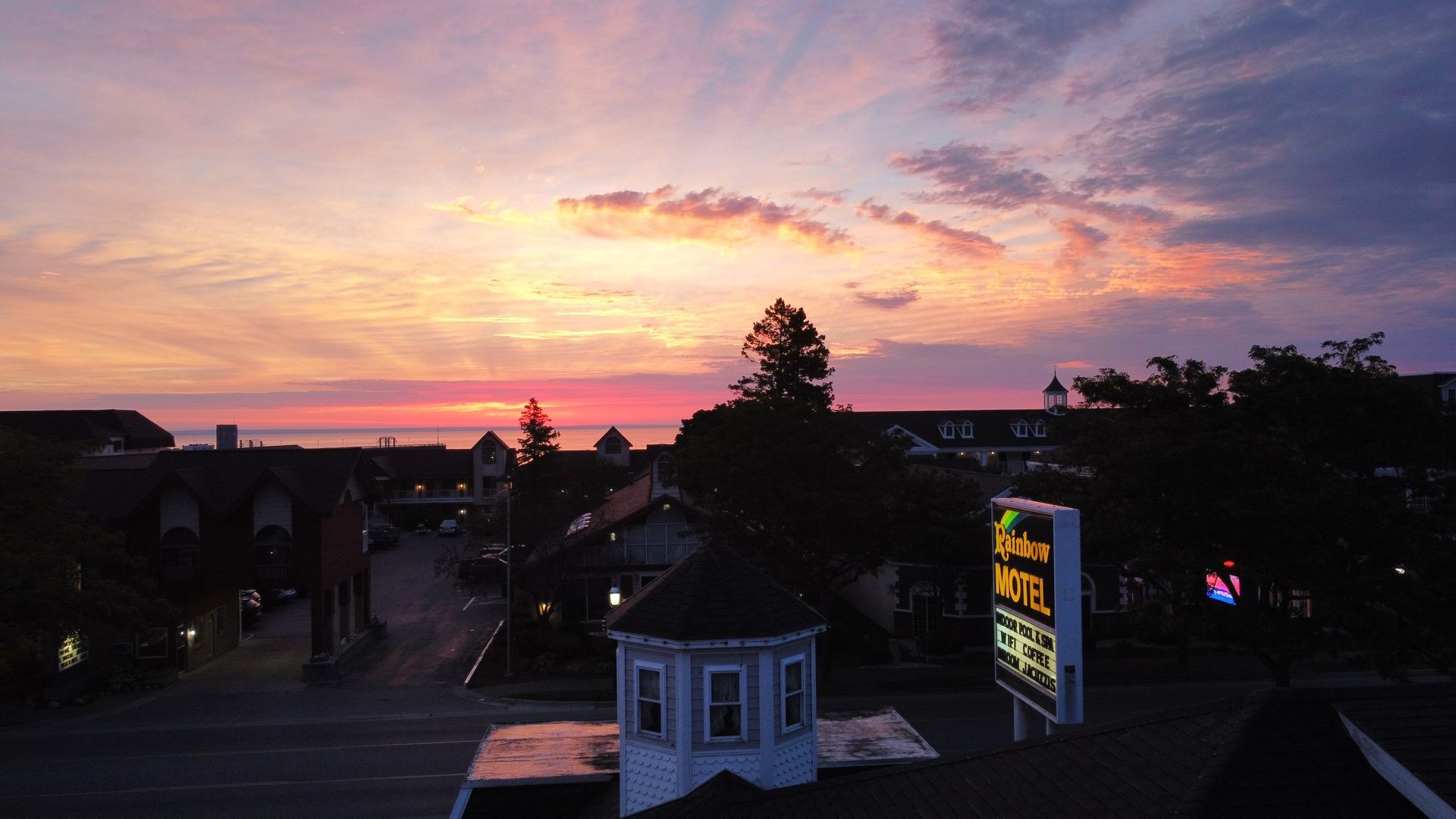 A sunset over a city with a sign that says motel on it