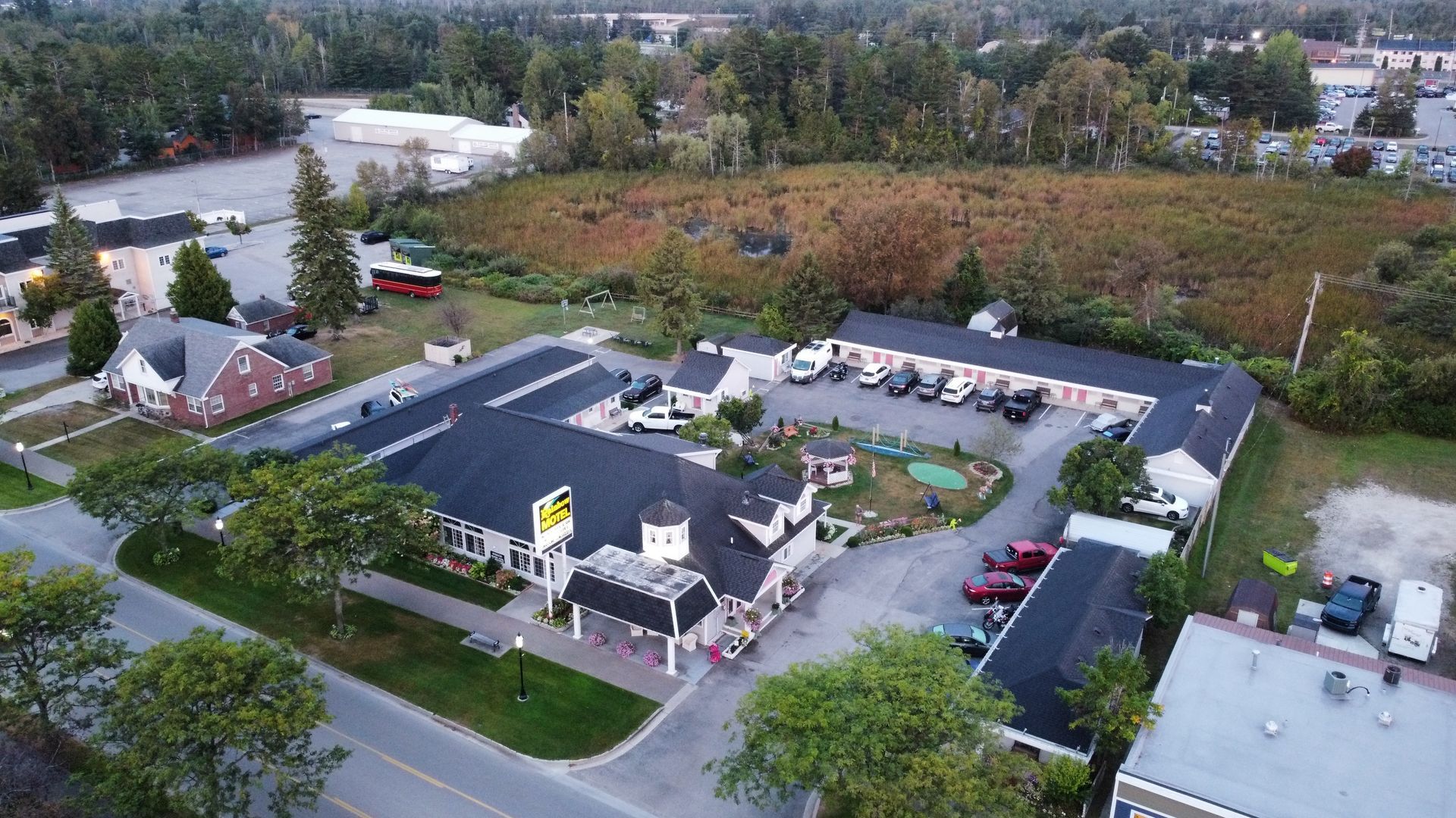 An aerial view of a motel with a lot of cars parked in front of it.