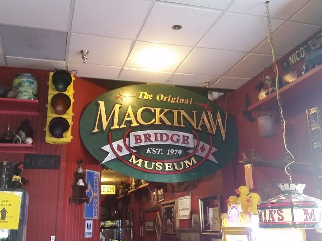 A sign for the mackinaw bridge museum hangs from the ceiling