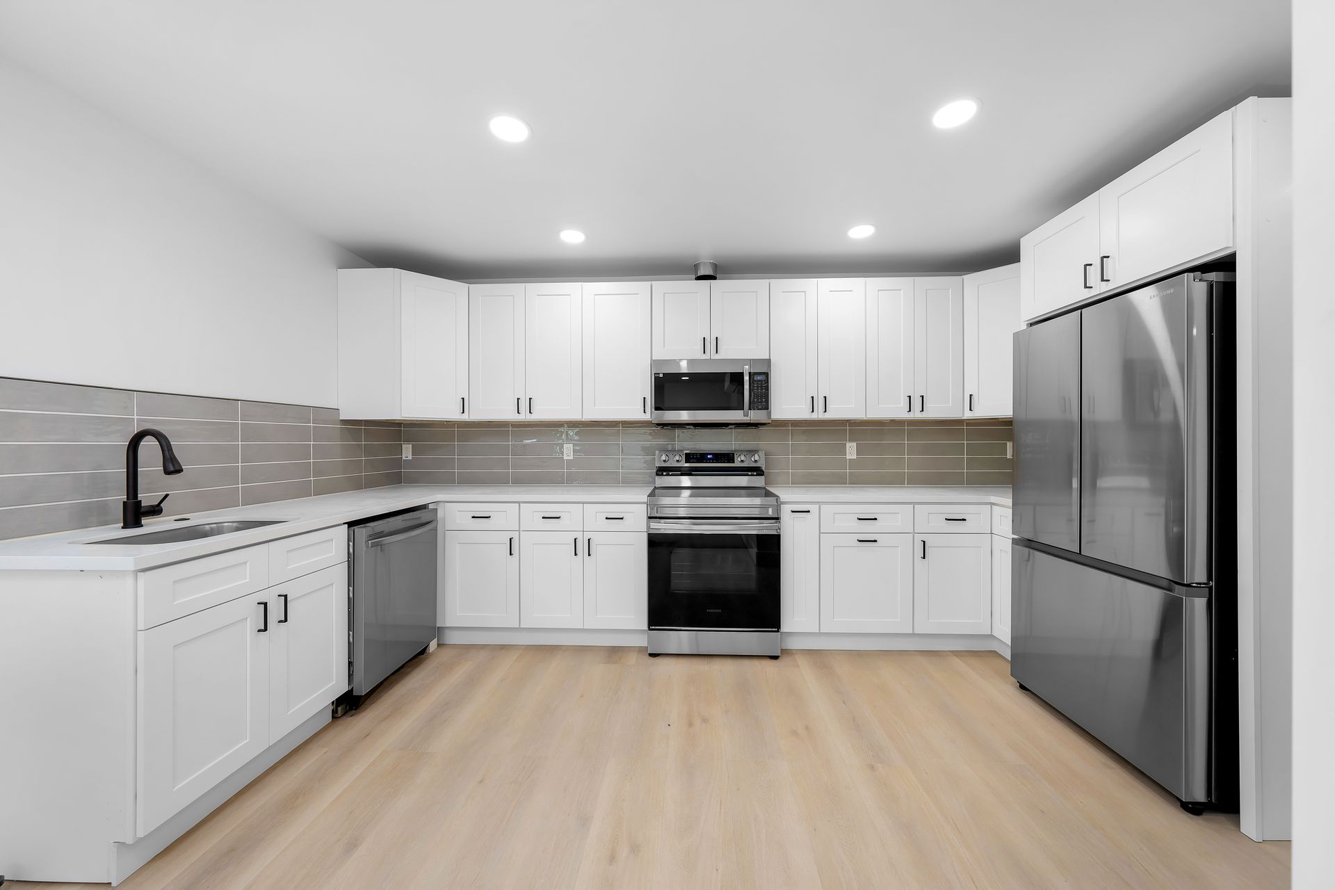 A kitchen with white cabinets and stainless steel appliances
