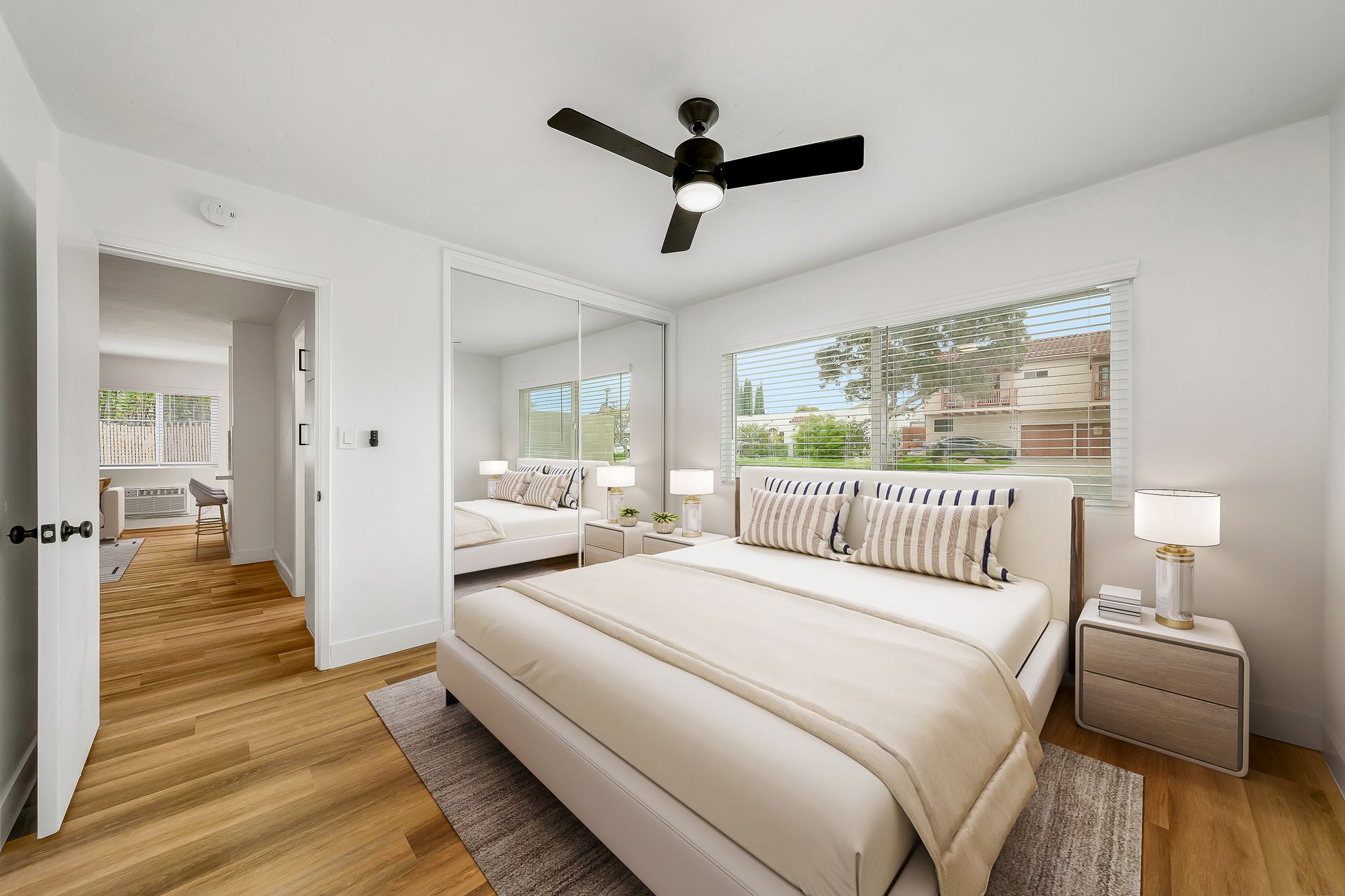A bedroom with a large bed and a ceiling fan.