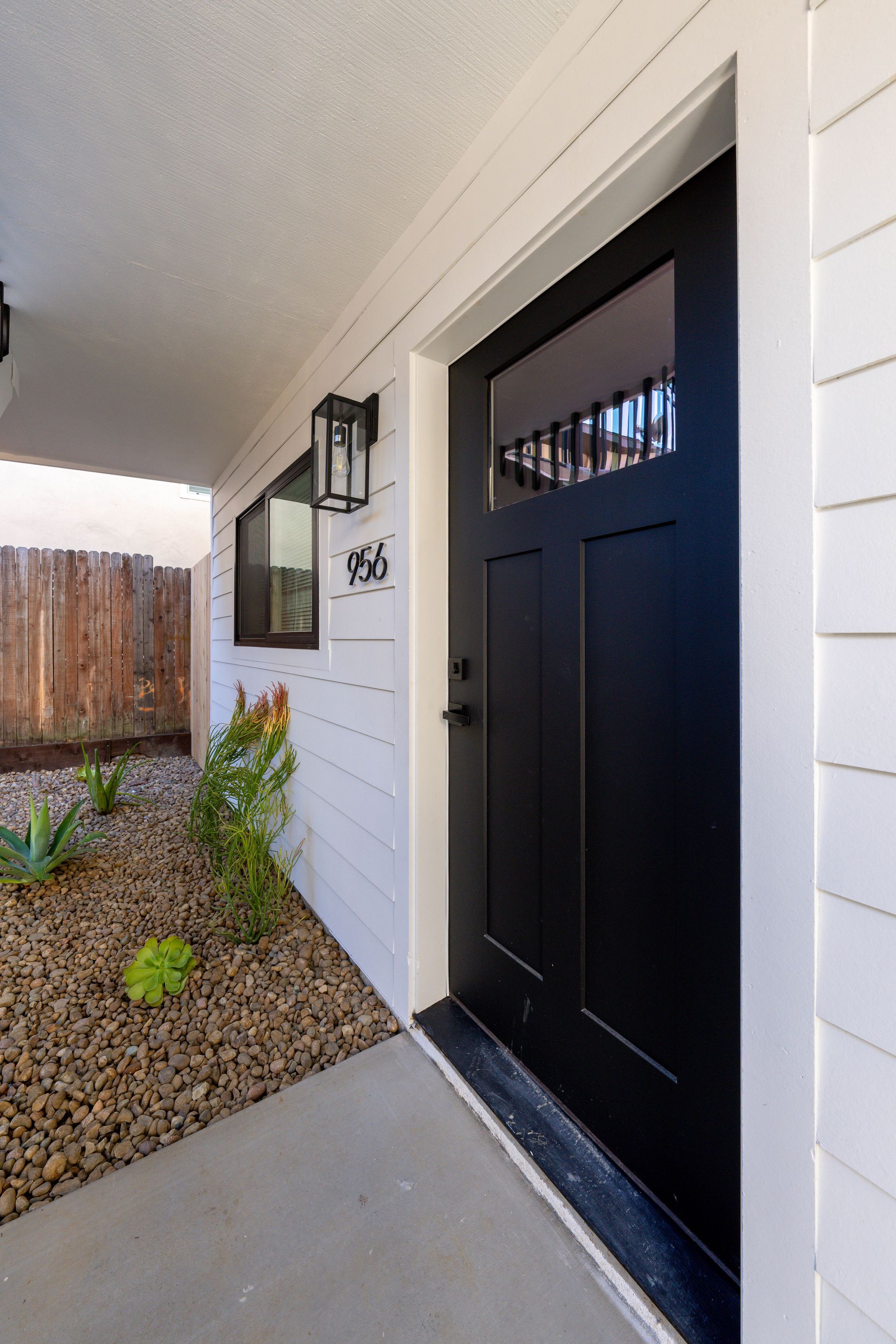 The front door of a white house with a black door