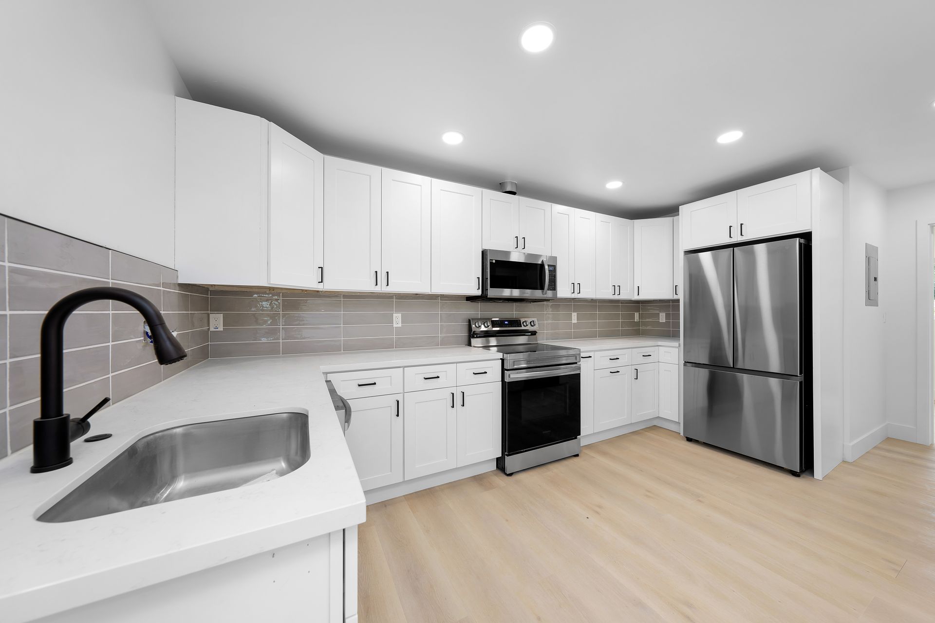 A kitchen with white cabinets and stainless steel appliances