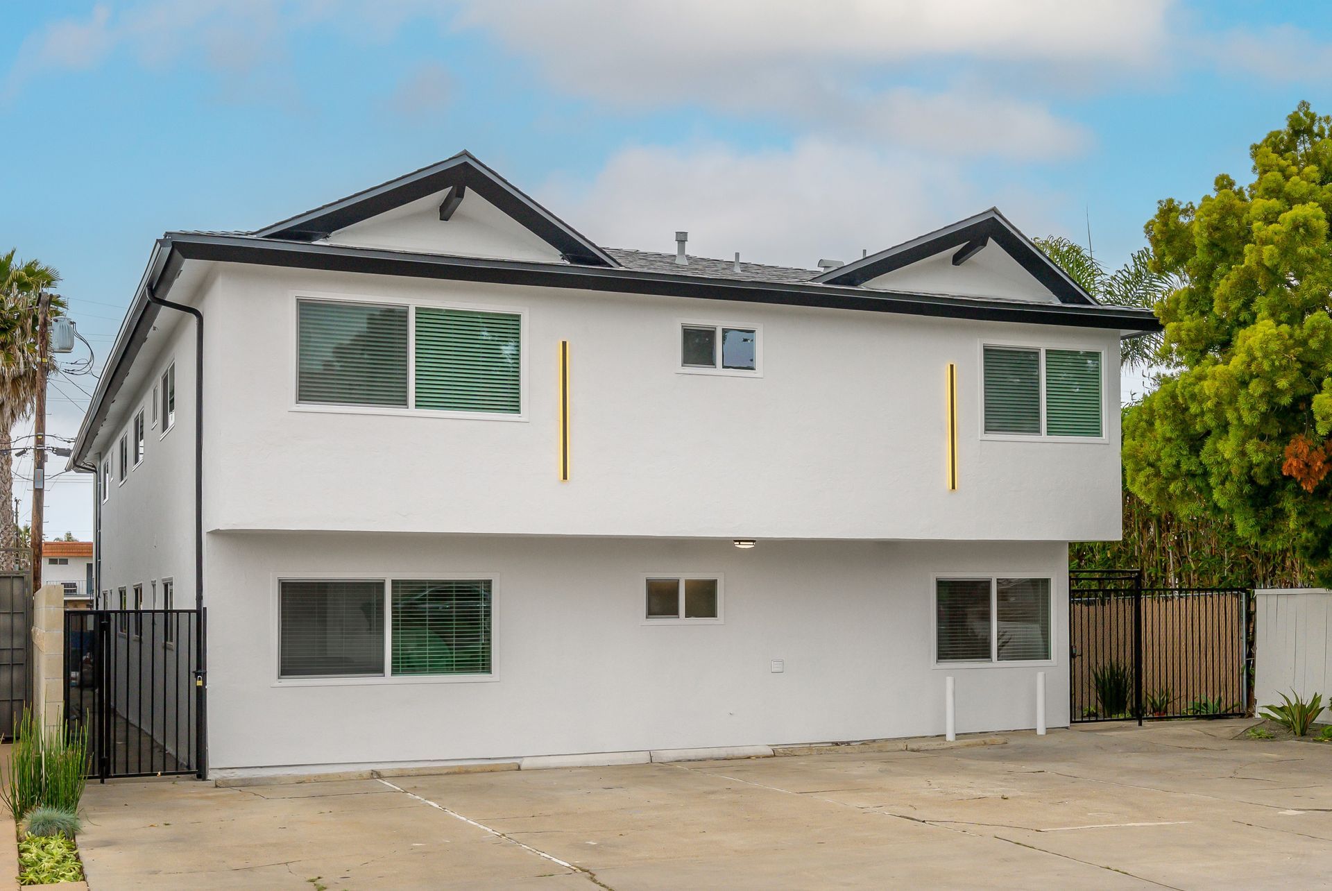 A white house with a black roof and a lot of windows