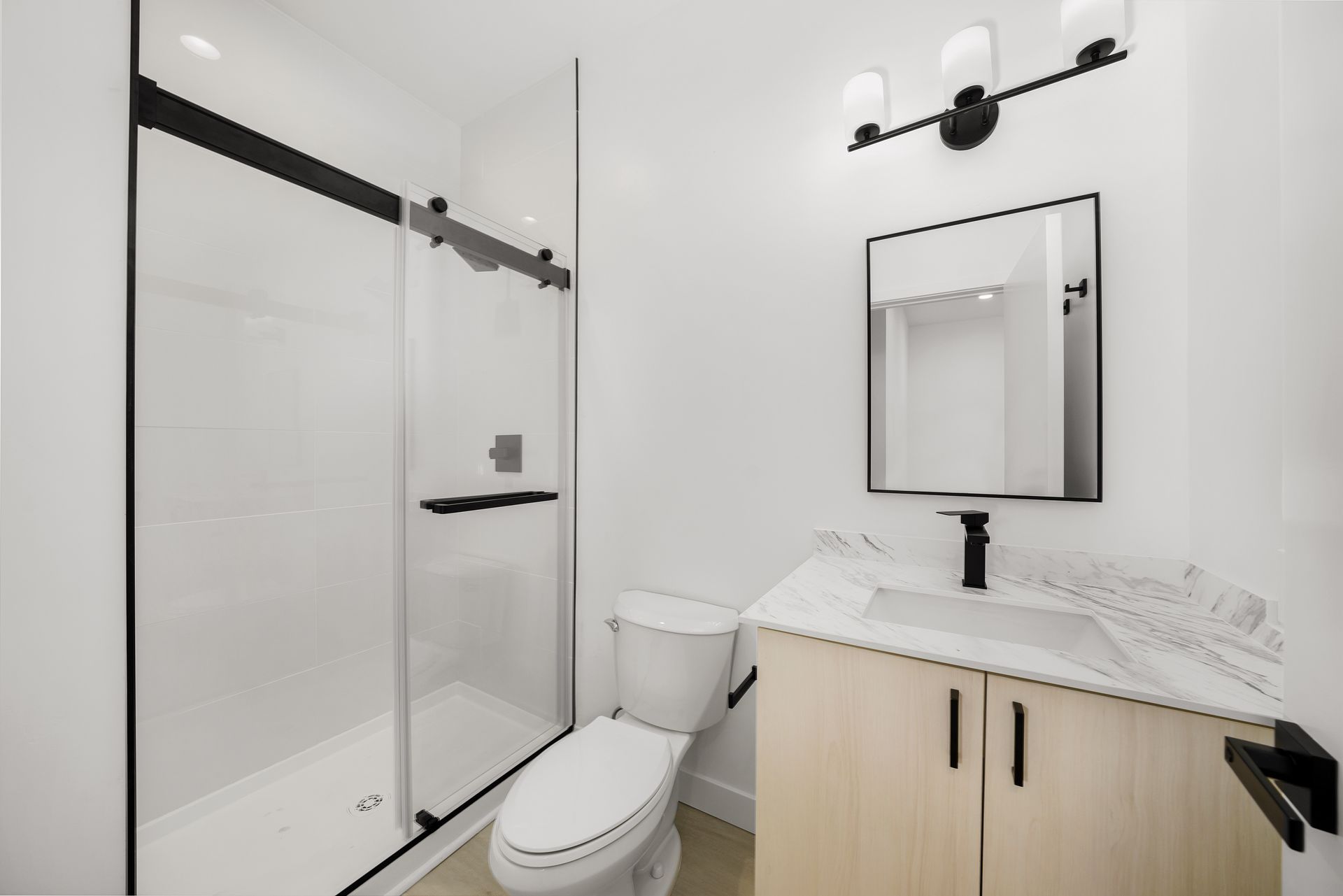 A bathroom with a toilet , sink and shower.