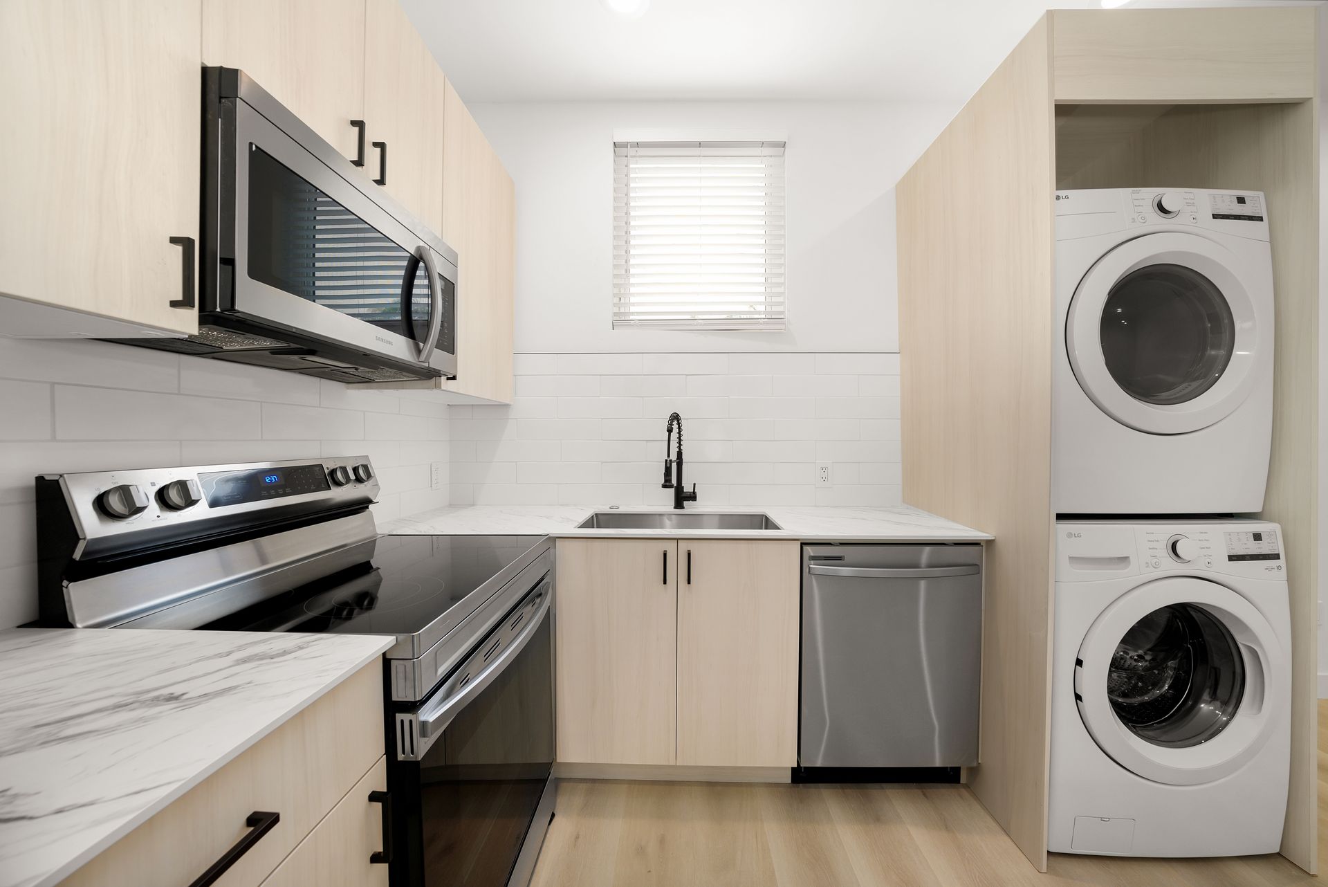 A kitchen with a washer and dryer stacked on top of each other