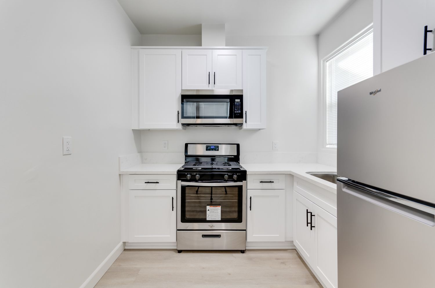 A kitchen with stainless steel appliances and white cabinets