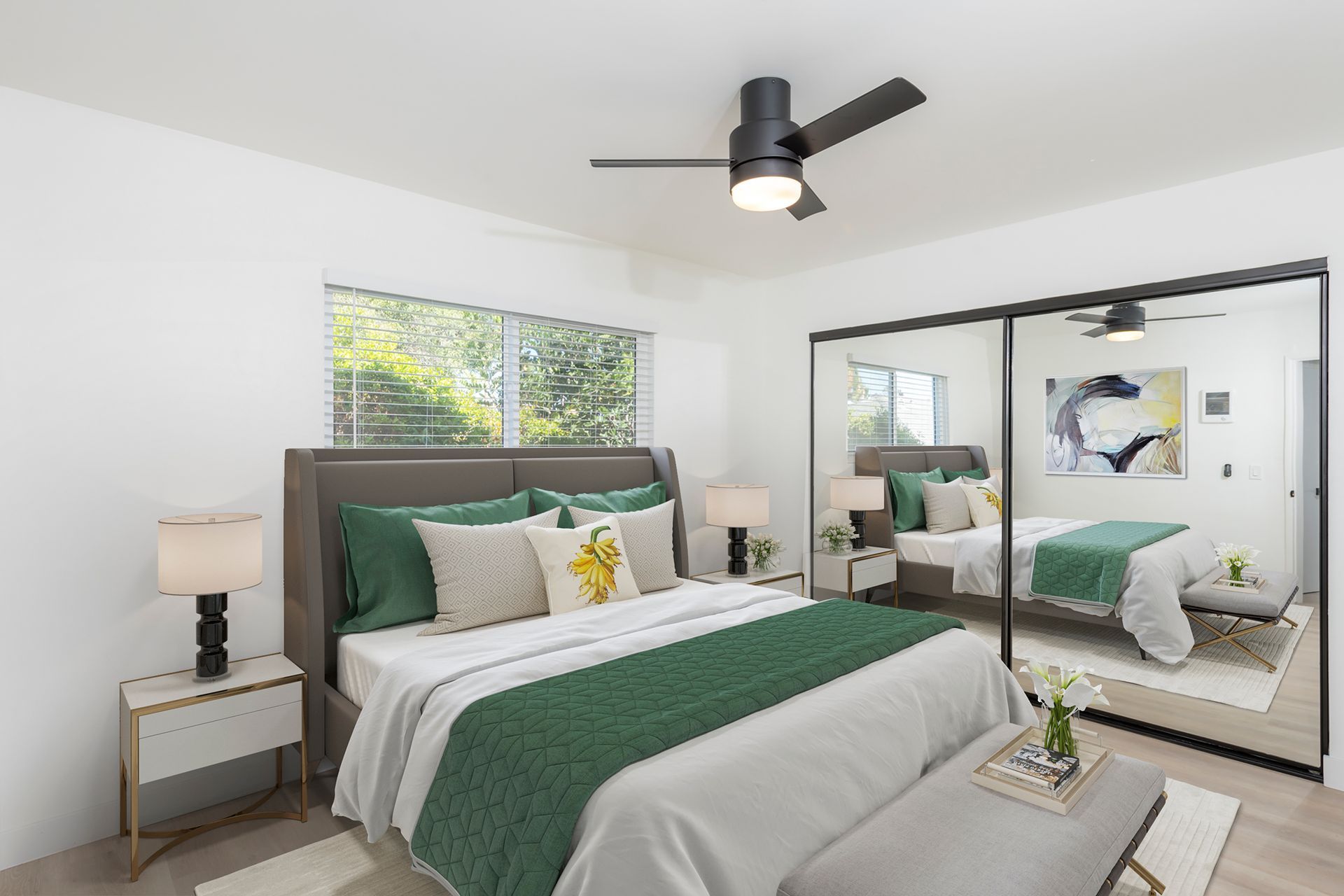 A bedroom with a large bed and a ceiling fan.