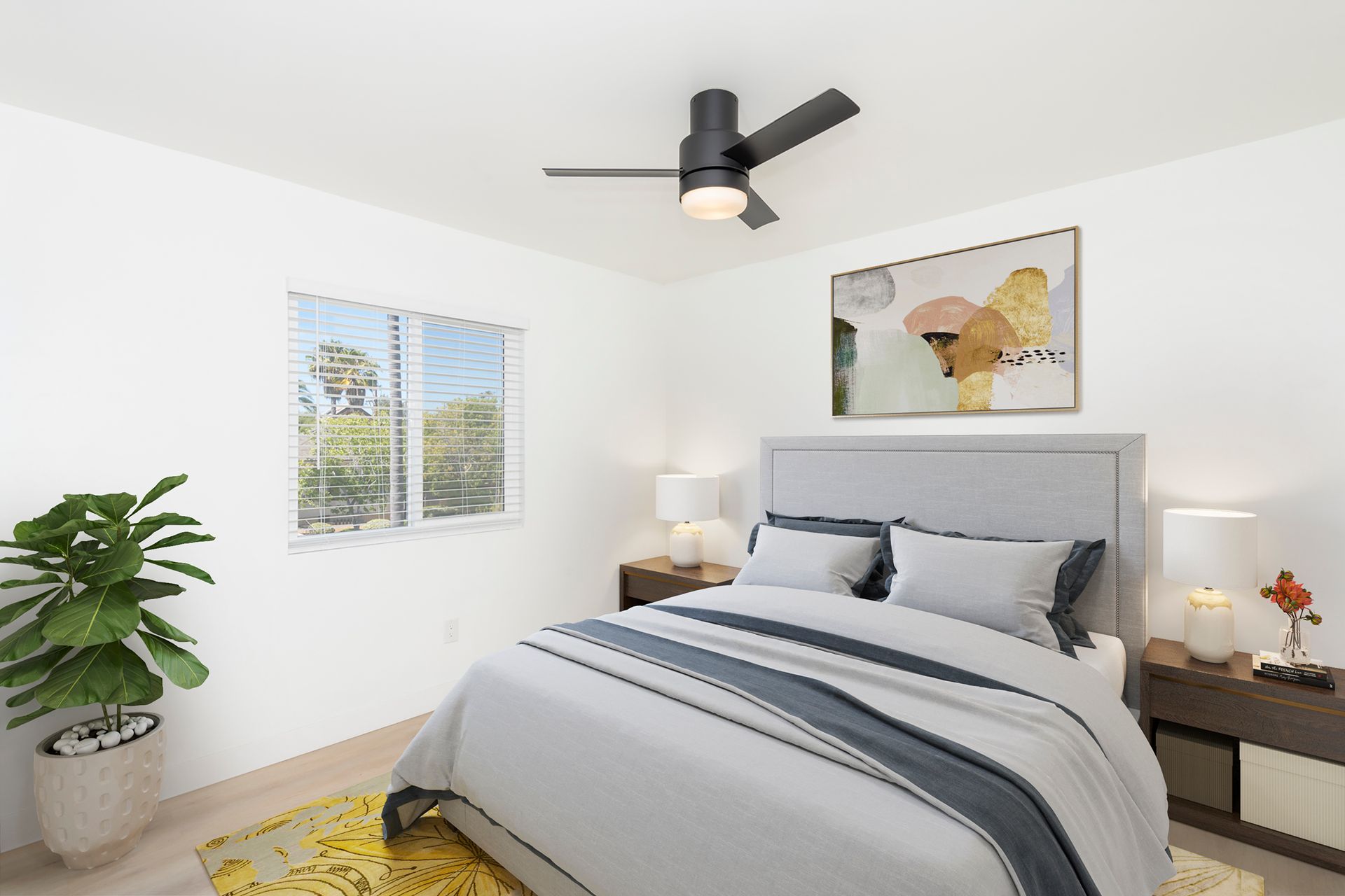 A bedroom with a bed and a ceiling fan.