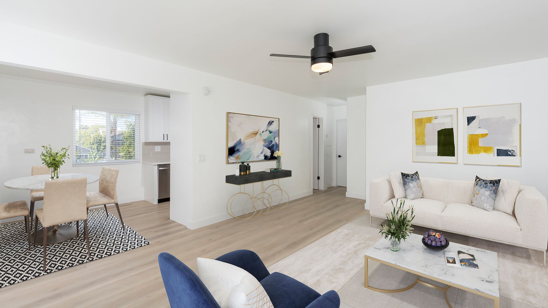 A living room with a couch , chair , coffee table and ceiling fan.