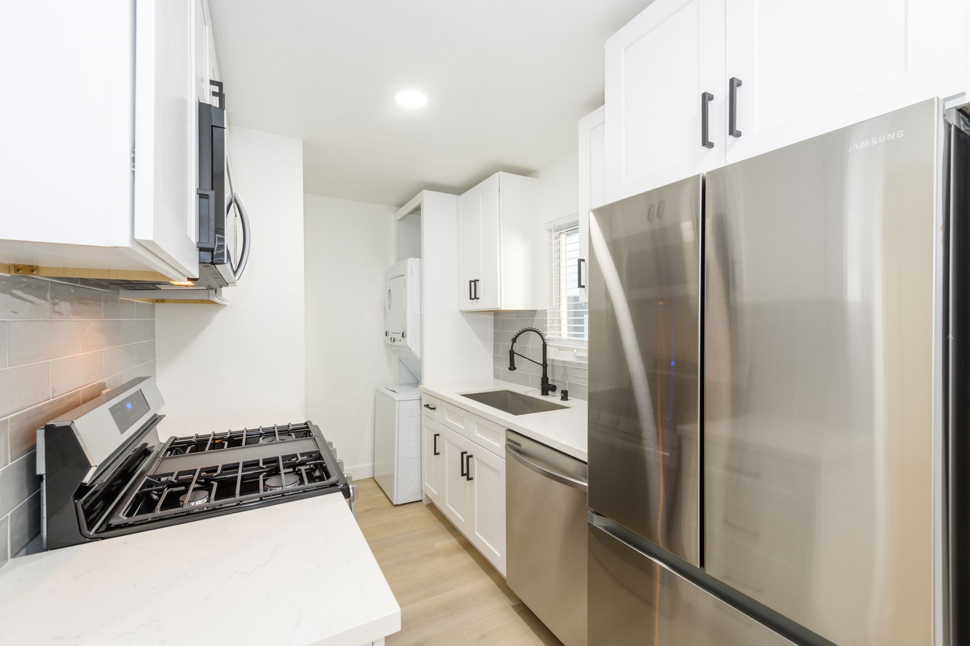 A kitchen with stainless steel appliances and white cabinets.