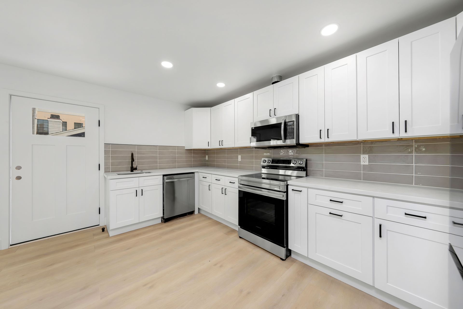 A kitchen with white cabinets and stainless steel appliances.