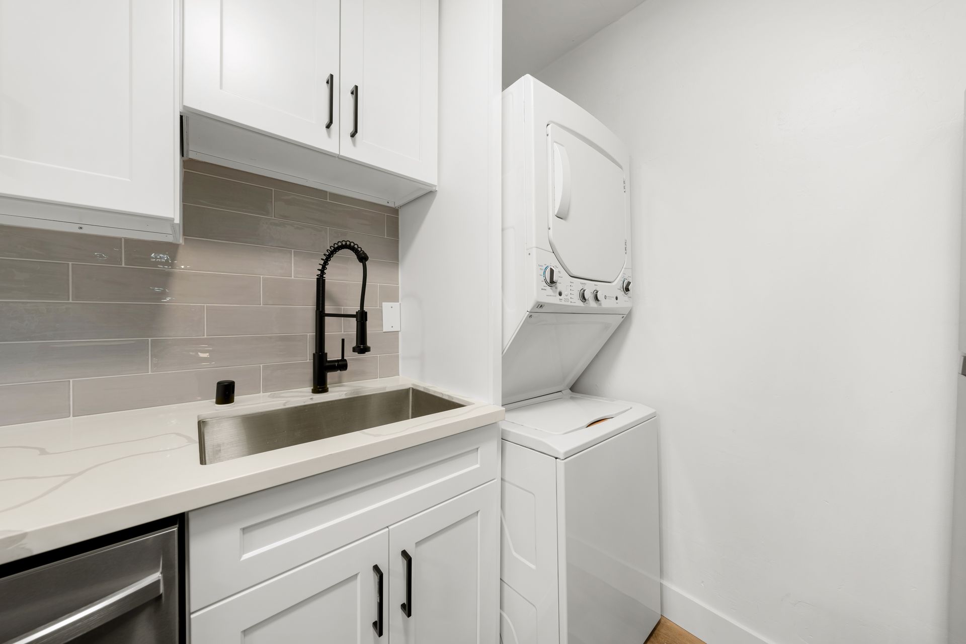 A laundry room with a washer and dryer and a sink.